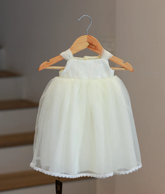 Front view of an off-white handworked tulle baptism gown for baby girls with floral embroidery and puffed sleeves.