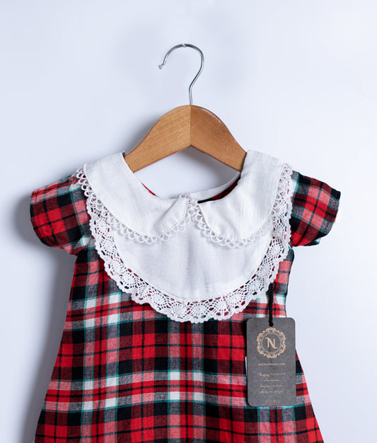 Close view of an red and black checkered cotton frock displayed on a hanger.