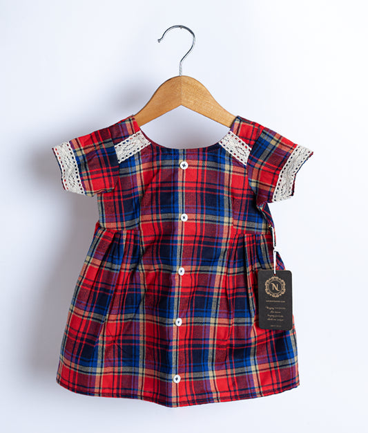A red and white checkered cotton frock displayed on a hanger.