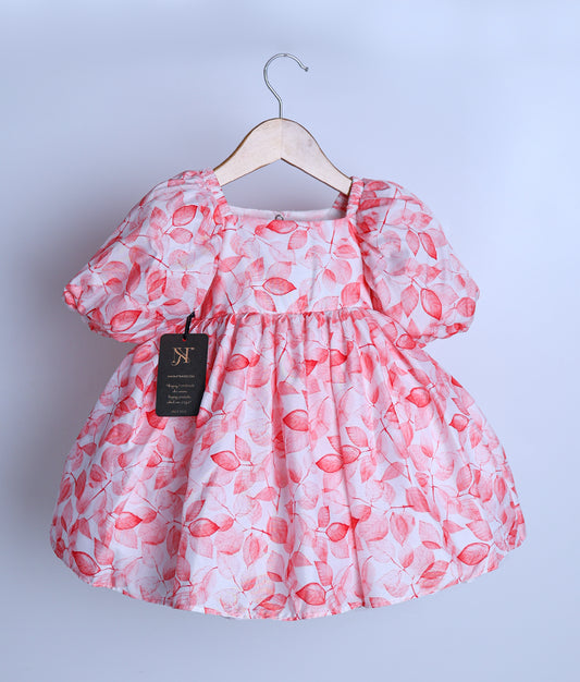 A light peach chiffon frock displayed on a hanger.