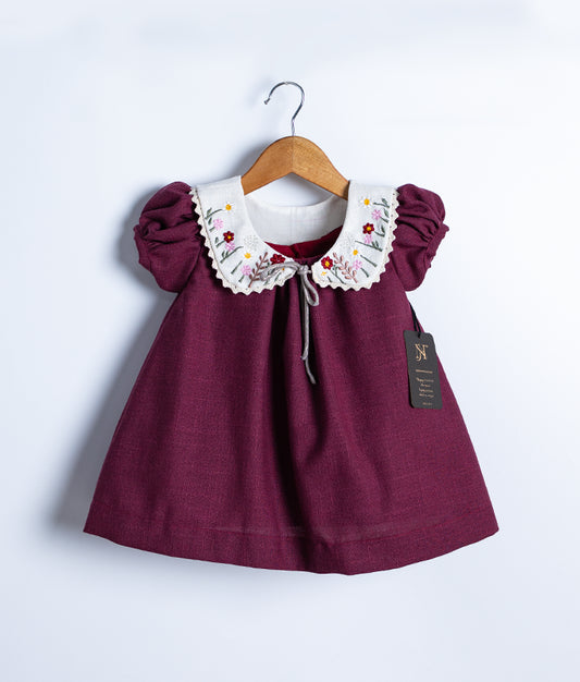 A grape wine colored frock is displayed on a white background.