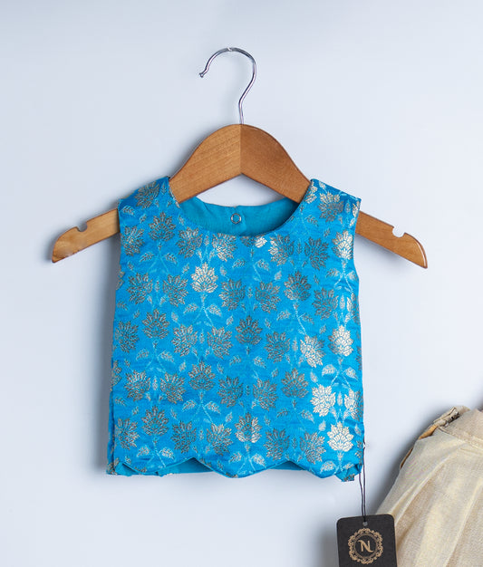 A kids ethnic wear set featuring a sleeveless blue brocade blouse with golden floral patterns and a gold flared skirt with sheer overlay, displayed on hangers.