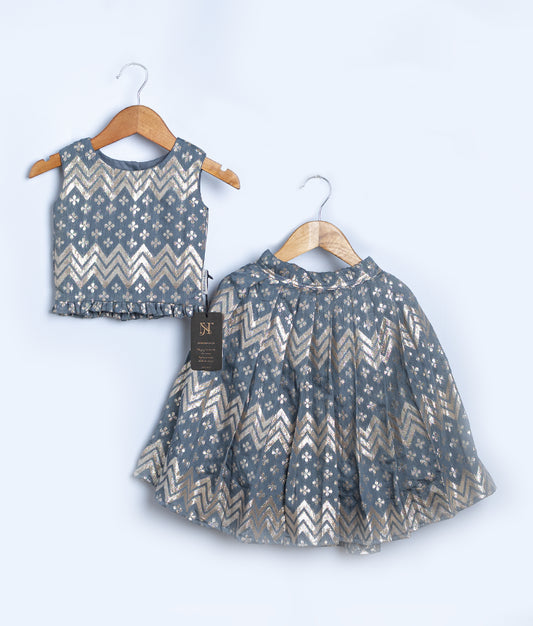 A two-piece outfit with a top and full-length skirt, featuring an ash color with a floral and zig zag pattern, displayed on hangers.