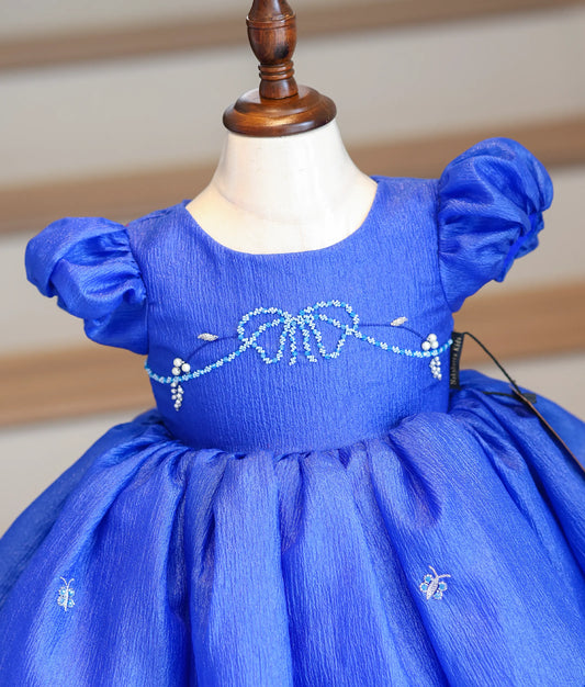 Close-up of the silver and light blue beadwork on the royal blue bodice and scalloped hem.