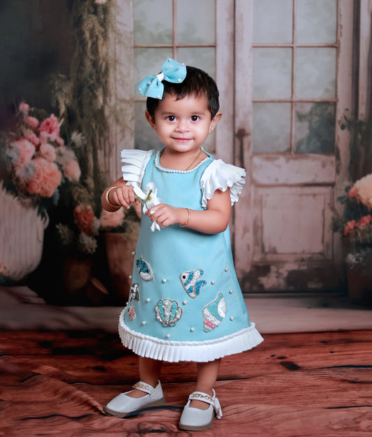 Front view of a blue mermaid theme A-line frock for baby girls with butterfly sleeves and off-white frills