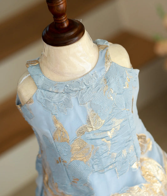 Close-up of the textured blue-gold leaf pattern and halter-neck detailing on the Turkish organza frock.