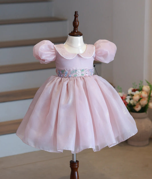 Front view of a dusty pink shimmer organza girl's birthday frock with peter pan collar and floral embroidery
