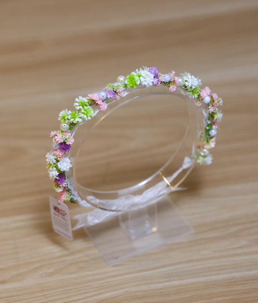 Close-up of the tiny pastel flowers and pearl bead detailing on the handcrafted floral birthday crown