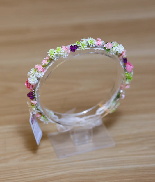 Close-up of the handcrafted tiara showing soft pink roses, white blossoms, and shimmering pearl accents
