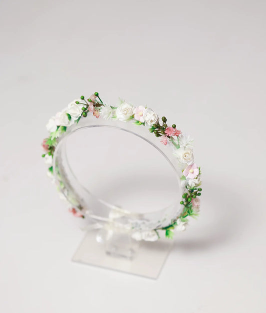 Close-up of the handmade tiara showing detailed white roses, pink flowers, and tiny green buds