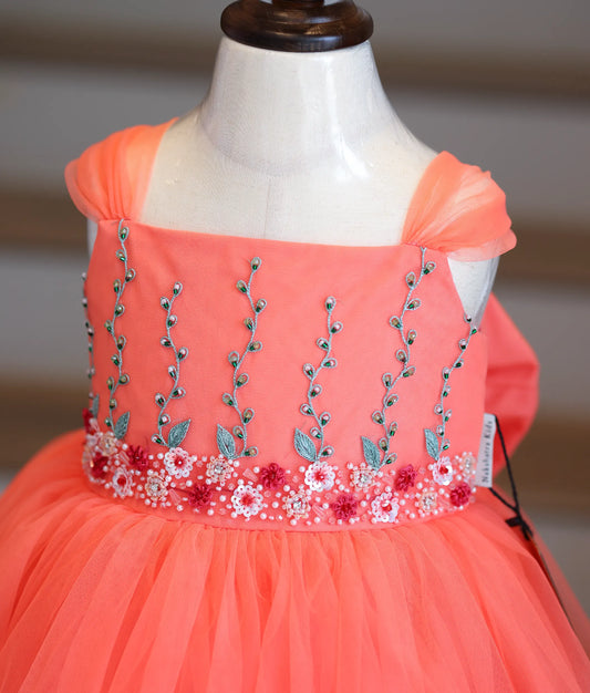 Close-up of the vertical floral vine embroidery and beads on the coral peach bodice.