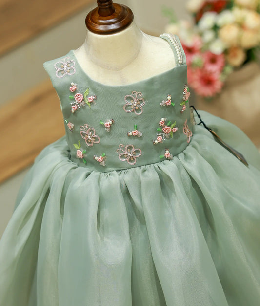 Close-up detailing of the intricate hand embroidery and premium satin organza fabric on green gown