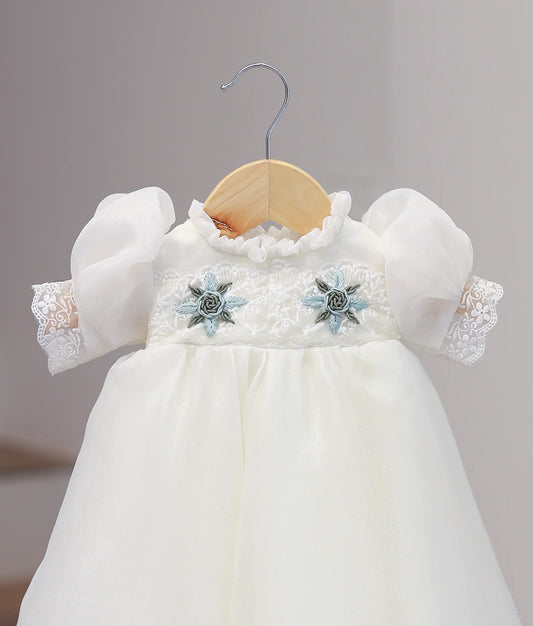 Close-up of intricate hand-stitched detailing on an off-white baby girl christening dress