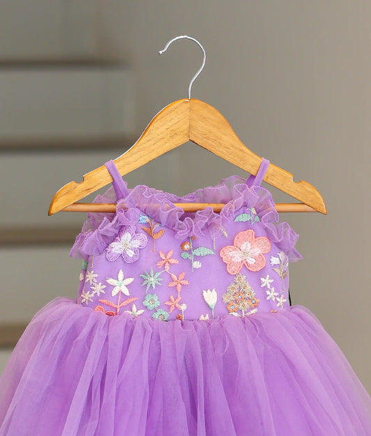 Close-up of the delicate hand-stitched floral embroidery with sequins and beads on the lavender birthday dress