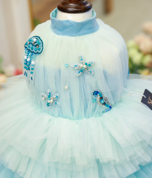 Close-up of the mermaid frock yoke showing seahorse and starfish embroidery and the high mandarin collar