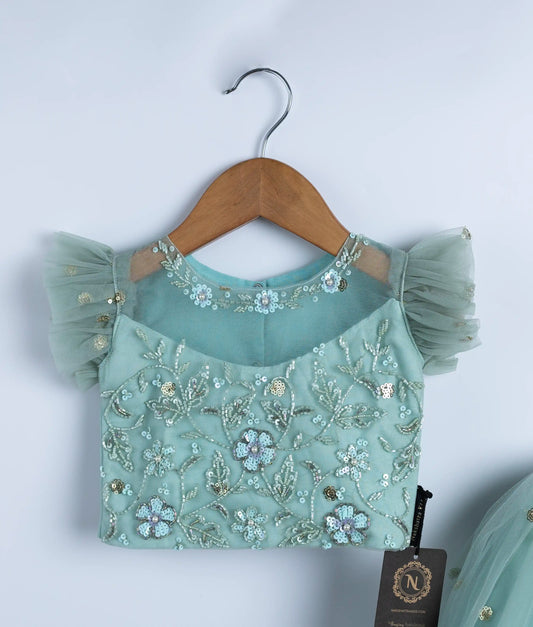 Close-up of mint green baby girl top with handmade sequin applique and cap sleeves