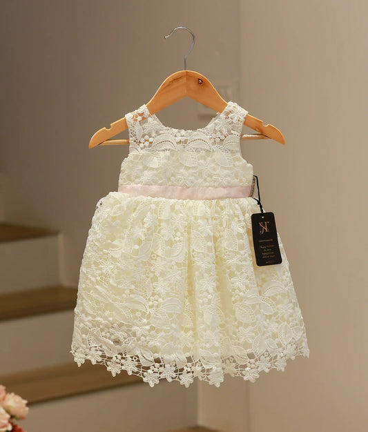 Front view of an elegant off-white baptism frock for baby girls featuring a classic crochet pattern and a soft flared skirt