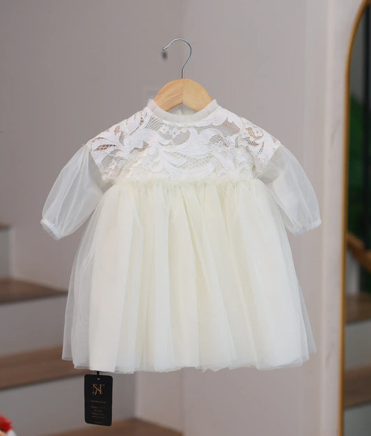 Full front view of an off-white baptism frock with a crochet floral yoke and frilled neckline.