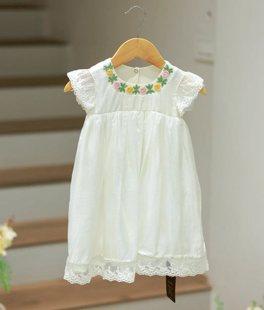 Front view of an off-white baptism frock for baby girls featuring delicate all-over embroidery and a graceful flared skirt.