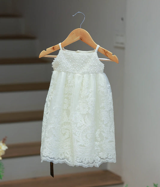 Full front view of an off-white baptism gown for baby girls featuring a pearl-embellished bodice and a premium floral lace overlay skirt.