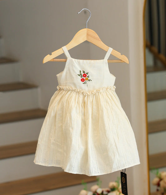 Front view of an off-white Kasavu cotton frock for baby girls with red and yellow floral hand-embroidery