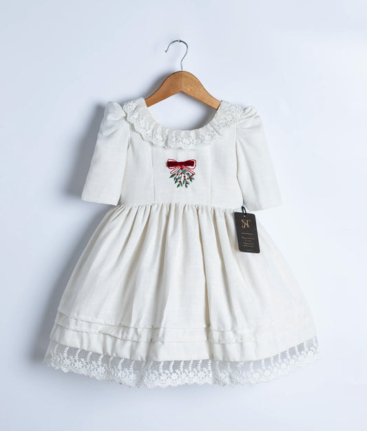 off-white linen frock showing the center embroidered design and round neckline.