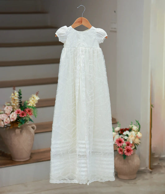 Full front view of a long-length off-white baptism frock for baby girls featuring short puff sleeves and a detailed work-fabric skirt