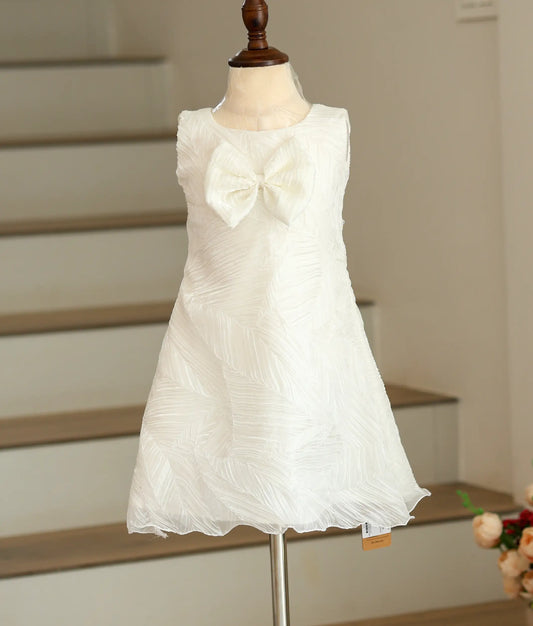 Front view of an off-white A-line frock in tuck organza with a decorative front bow.