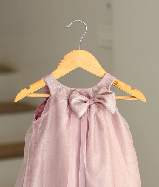 Close-up of the frock with a bow on the onion-pink birthday dress