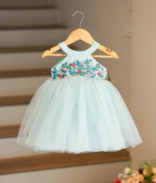 Full front view of a pastel blue below-knee-length tulle frock featuring a beaded halter neck and voluminous skirt.