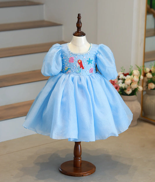 Front view of a pastel blue crush organza mermaid theme birthday frock for baby girls with puffy sleeves