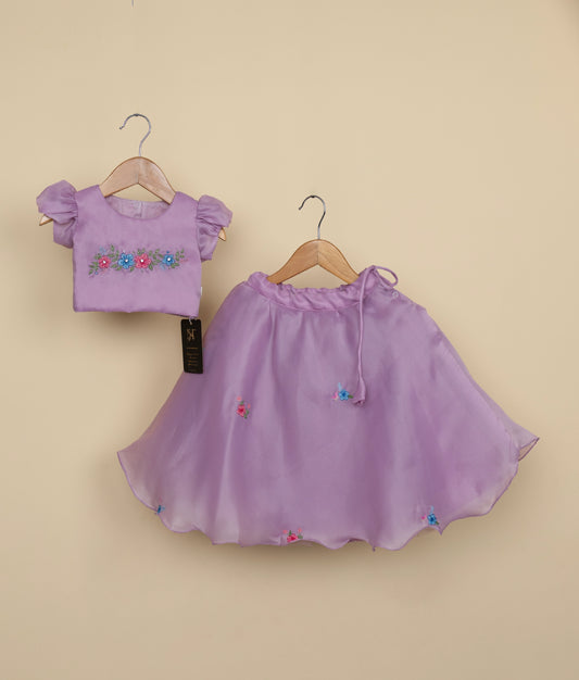 Front view of a pastel lavender girl's crop top with floral embroidery and a voluminous layered tulle full-length skirt
