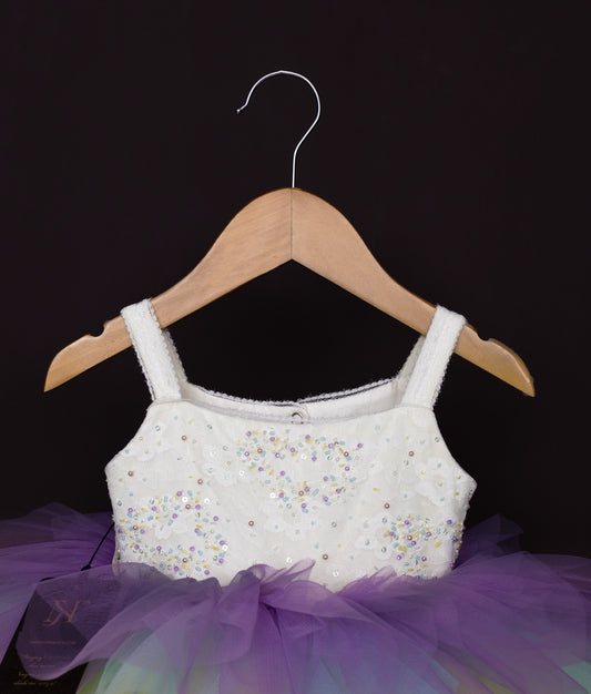 Front view of pastel rainbow dress with white top and colorful tulle layers in soft rainbow hues