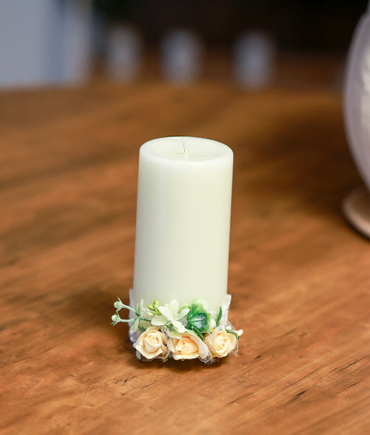 Close-up of the handcrafted peach roses, pearls, and delicate beadwork on the decorative baptism candle
