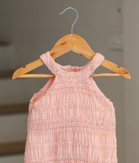 Close-up of the horizontal ruffled tiers and halter neck design on the peach georgette fabric.