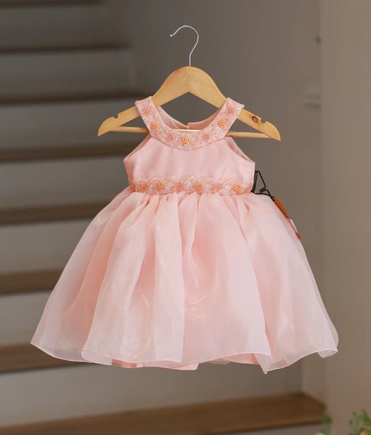 Full front view of a peach shimmer organza below-knee birthday frock with a halter neck and handworked yoke.