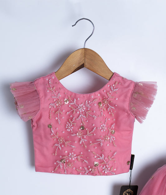 Close-up of pink embroidered top of baby girl dress
