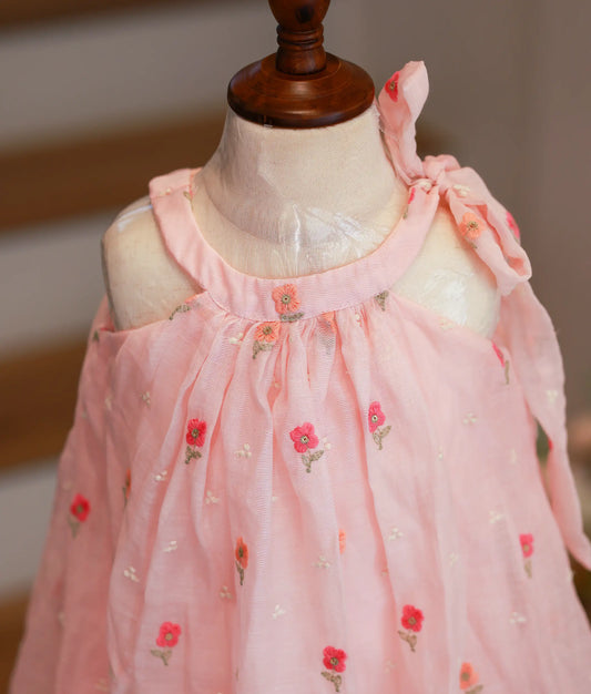 Close-up of the pink frock highlighting the gathered halter neckline and detailed floral embroidery on the Chanderi fabric.