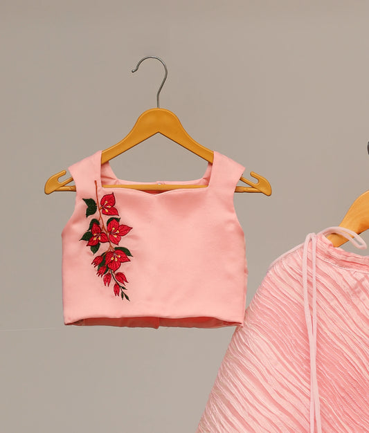 Close up of the detailed floral embroidery on the pink square-neck top for baby girls