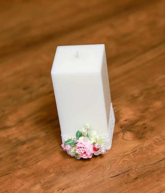 Close-up of the handcrafted pink roses, white pearls, and the delicate layered ribbon on the baptism candle