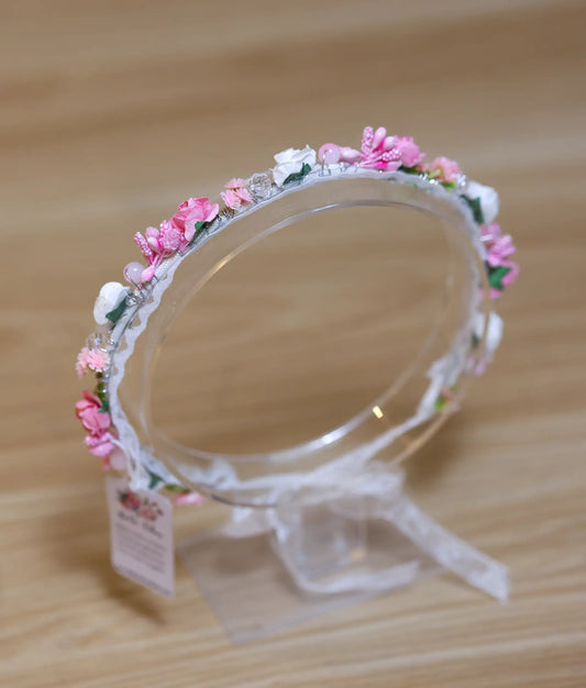 Close-up of the handcrafted pink flowers, white buds, and pearl bead detailing on the floral birthday crown