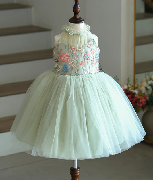 Front view of a powder green party frock for girls with a floral-embroidered top and ruffled collar.