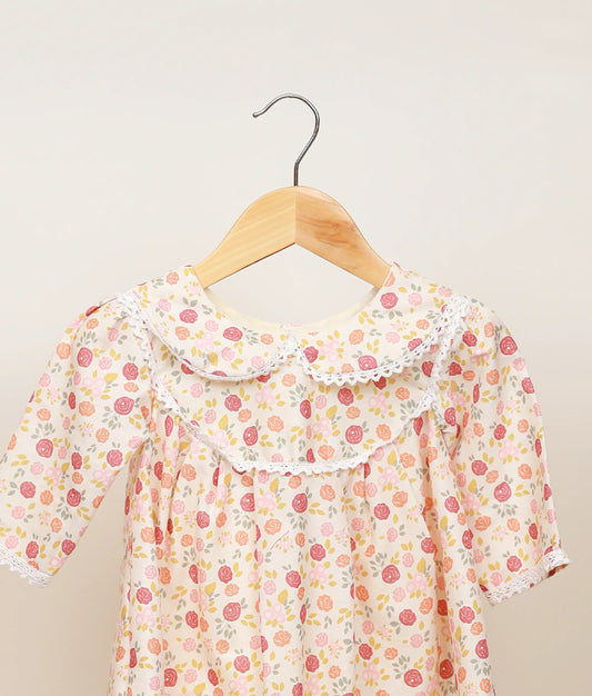 Close view of the printed cotton yoke and lace detailing around the round neckline of the dress.