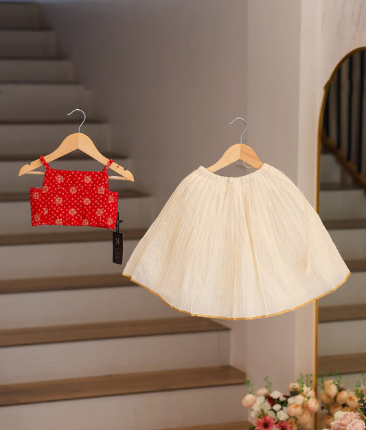 Front view of a traditional red crepe top and off-white pleated Kasavu skirt for baby girls