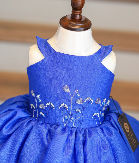 Close-up of the silver and light blue beadwork on the royal blue bodice and scalloped hem.