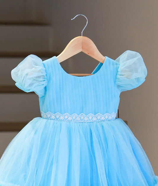 Close-up of the sky blue frock highlighting the white floral lace handwork at the waist and vertical pleated texture.