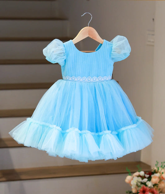 Full front view of a sky blue below-knee party frock for girls featuring a pleated bodice and ruffled tulle skirt.