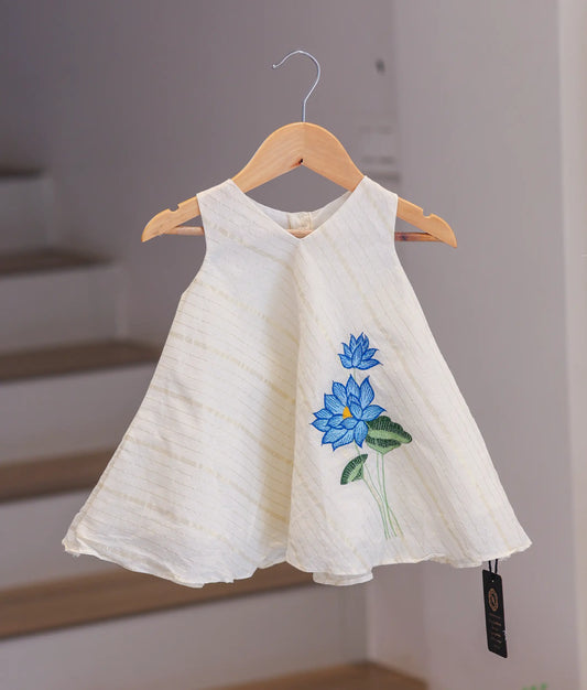 Front view of a traditional off-white Kasavu cotton frock with gold borders for Onam and Vishu