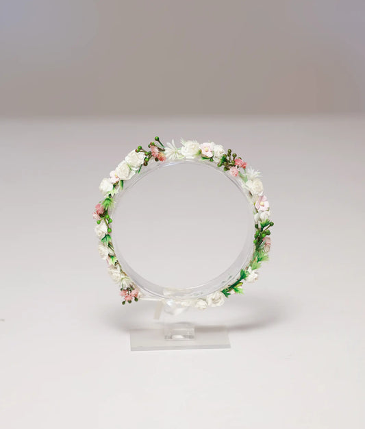 Front view of a white and pink spring blossom handmade tiara for kids with green leaf accents