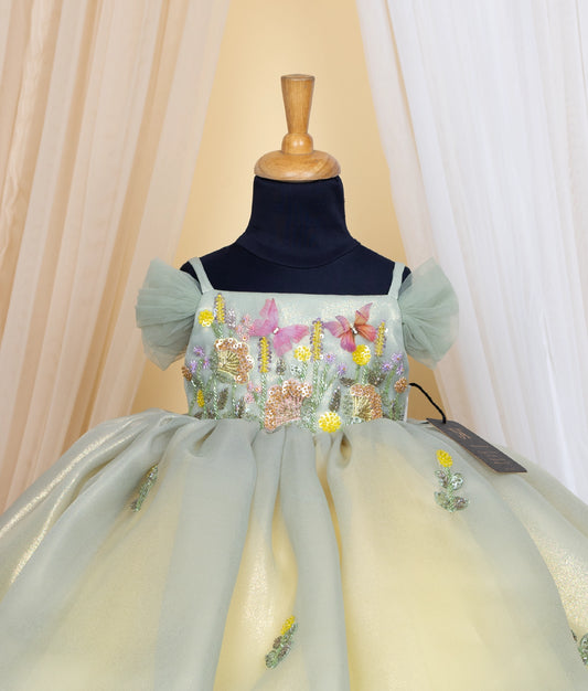 Close view of an pastel green and yellow frock displayed on mannequin.
